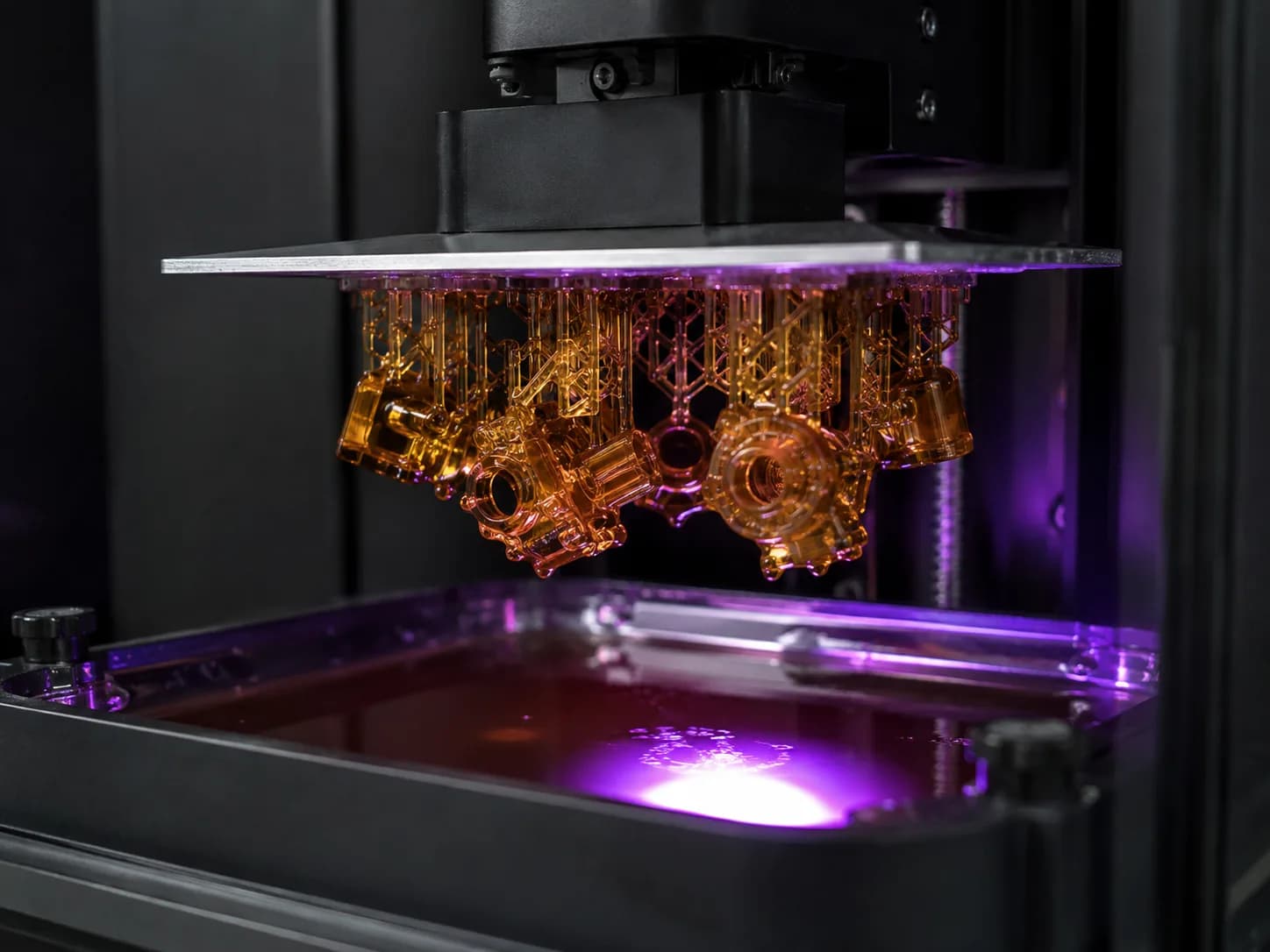 Amber resin components lifting from a DLP printer vat